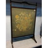 A mahogany framed needlework fire screen