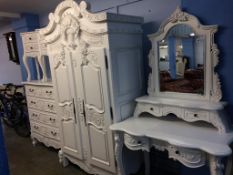 A decorative modern white bedroom suite, comprising wardrobe, chest of drawers, dressing table and