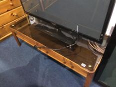 A smoked glass and teak coffee table