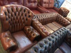 A Chesterfield brown three seater settee and three armchairs