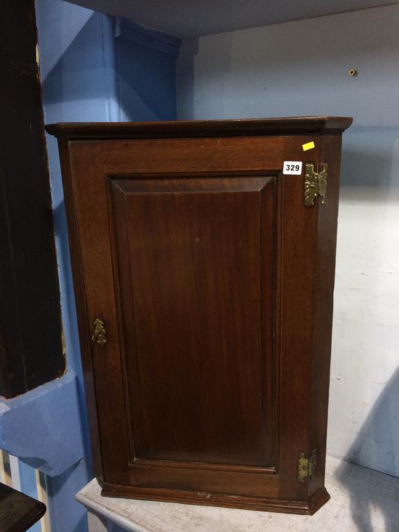 An oak hanging corner cabinet