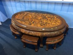 An Oriental carved oval table, with six small tables