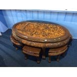 An Oriental carved oval table, with six small tables