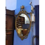 An ornate gilt oval mirror, 100cm height