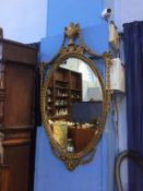 An ornate gilt oval mirror, 100cm height