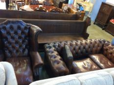 A brown leather Chesterfield three seater settee and high back armchair