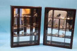 Two small display cabinets, each with various miniature glass objects