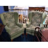 A pair of wingback armchairs and a footstool