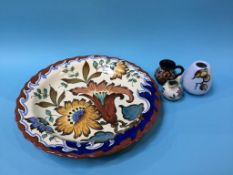 A large Gouda wall plaque and three small pieces of Gouda pottery, 36cm diameter