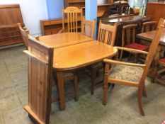 An oak Arts and Crafts extending dining table and six (4+2) chairs, 142cm unextended, with two