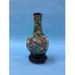 An Oriental vase on carved hardwood stand