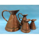 A set of four graduated copper jugs