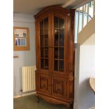 A reproduction mahogany carved corner cabinet