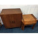 A teak cabinet and a nest of tables