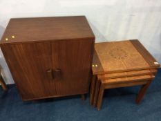 A teak cabinet and a nest of tables