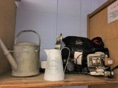 A shelf of assorted, to include watering cans and hedge trimmer etc.