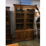 An oak glazed two door bookcase