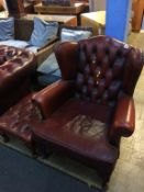 A Chesterfield wing armchair and Chesterfield stool