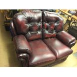 A burgundy leather two seater settee