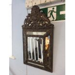 A copper embossed bevelled edge mirror