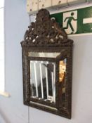 A copper embossed bevelled edge mirror