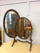 A mahogany oval mirror and a dressing table mirror