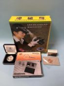 A silver coin, set of scales and magnifier etc.