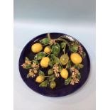 A Continental circular wall plaque, decorated with applied foliage and lemons, 37cm diameter