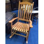 A large slatted back and seat rocking chair