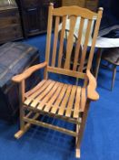 A large slatted back and seat rocking chair