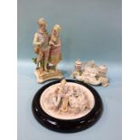 A Continental porcelain inkwell, a framed bisque circular plaque and a figure group (3)