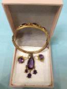 A 9ct gold bangle, mounted with amethysts and seed pearls, 12g and a pair of similar earrings and