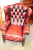 A burgundy Chesterfield armchair