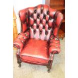 A burgundy Chesterfield armchair