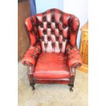 A burgundy Chesterfield armchair