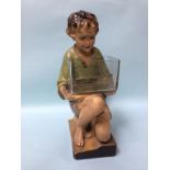A 1930s plaster model of a kneeling boy holding a glass fish bowl. 52cm high