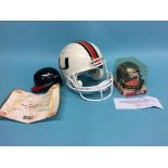 A mini Baseball helmet, signed Chipper Jones and Tom Glavine, Atlanta Braves, a mini NFL helmet,