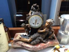 An ornate French style clock, with 8 day movement and enamelled dial