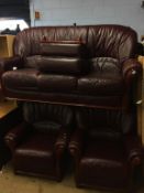 A burgundy leather three piece suite