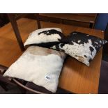 Two cow hide rugs and three cow hide cushions