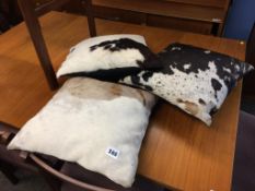 Two cow hide rugs and three cow hide cushions