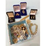 Box of assorted costume jewellery, a 9ct ring, various brooches etc.