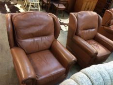 A pair of brown leather armchairs