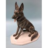 A porcelain model of a seated German Shepherd dog