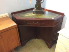 A reproduction mahogany corner desk