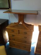 A pine chest of drawers and a coffee table
