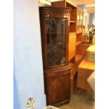 A reproduction mahogany corner cabinet