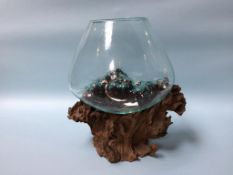 A glass fish bowl on wooden stand