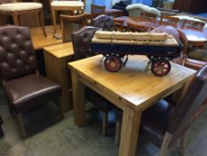 A modern oak fold out dining table, four chairs and a small cabinet