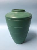 A Wedgwood Keith Murray cylindrical tapering vase on a dark green ground, 29cm height